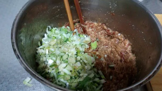 从冰箱中拿出肉馅，放入葱，将香油倒在葱上搅拌均匀