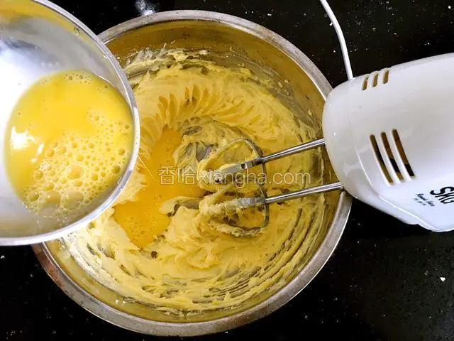 再电动打发至颜色发白，体积微微膨胀，将鸡蛋液分三次加入到黄油中，每次都搅打均匀，避免油水分离。