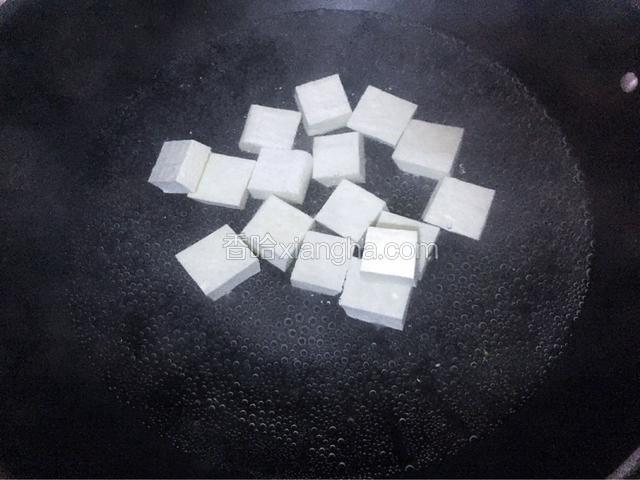 锅中倒入清水烧开加入适量的盐，再放入豆腐，再次烧开后捞出豆腐沥干水分备用