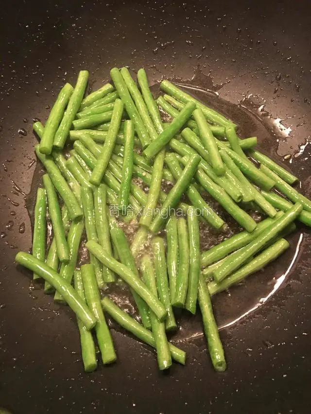 热锅下油，待油温有少许热。下豆角走油至变色断生