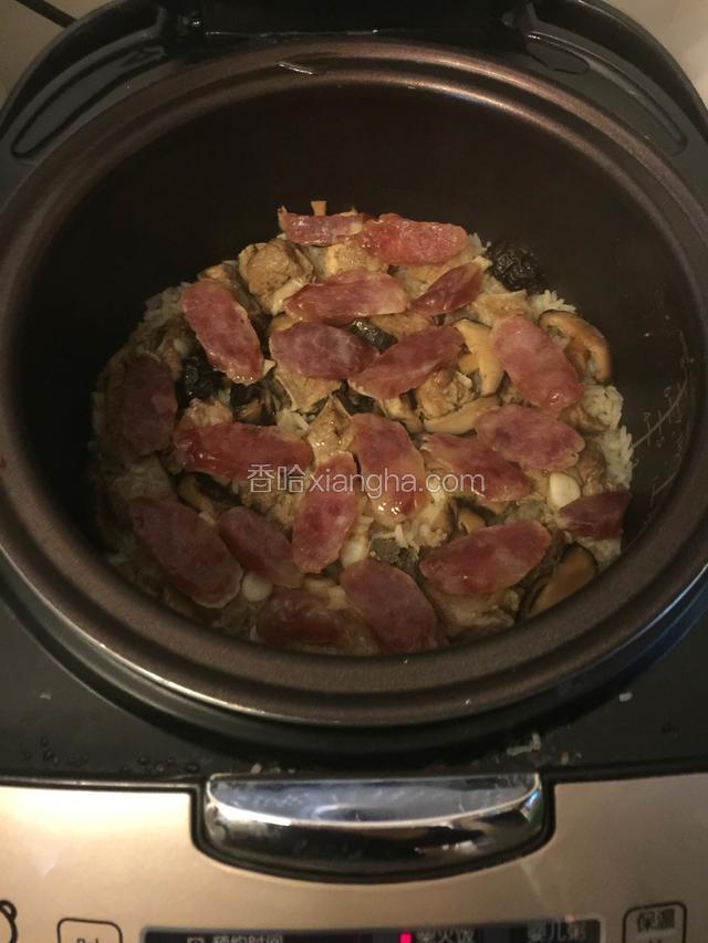 等饭还有八分钟快好的时候，把切好的腊肠放入，再盖上盖子