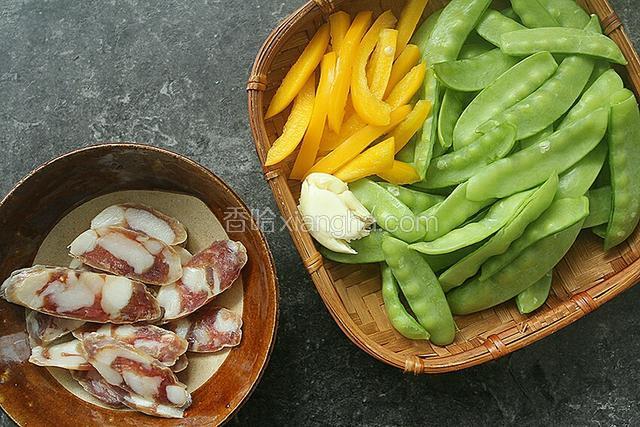 摘好荷兰豆，腊肠切片，黄椒切丝，蒜拍扁