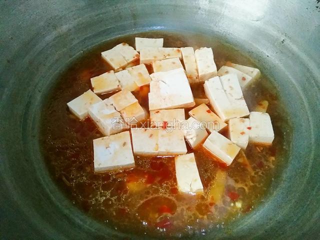 倒入步骤3的豆腐块，将炒锅来回晃动几下，使豆腐均匀的散在锅里。
