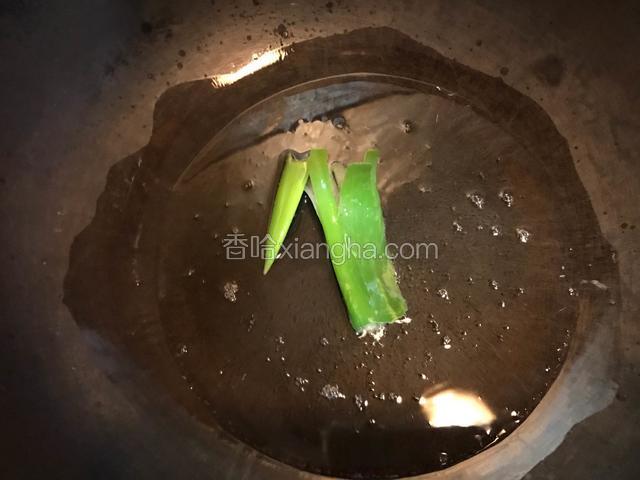 大葱2段，炒锅烧热后倒入适量食用油，油温6-7成热时放入葱段爆香。