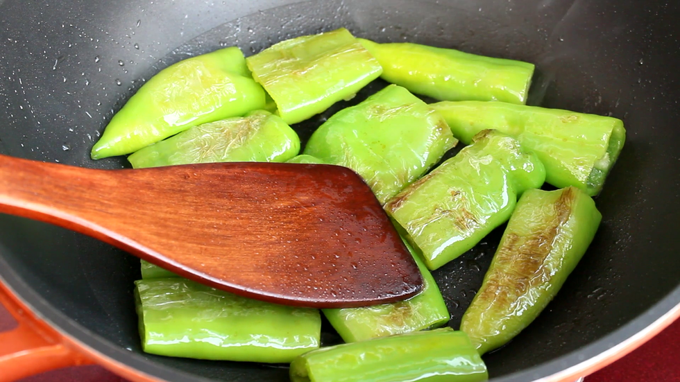 用锅铲按压青椒，使青椒里的水汽排出