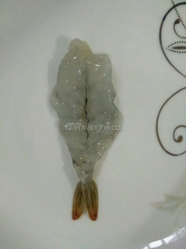 从背部刨开，注意不能切断，去掉虾线，用刀背将虾肉拍松。