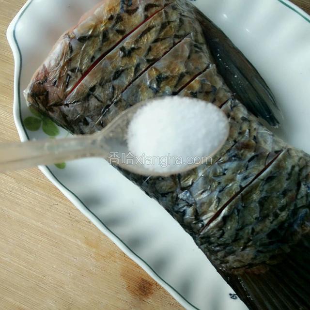在鱼尾两面各切几刀，撒些盐、料酒腌一个小时后，擦干腌汁