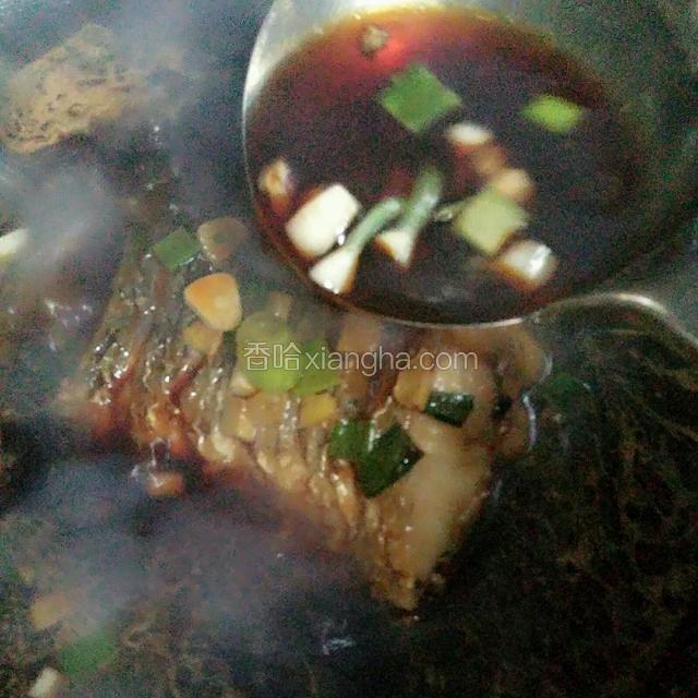 一面煮一面用手勺舀汤汁浇在鱼尾上，中途把鱼尾翻个身