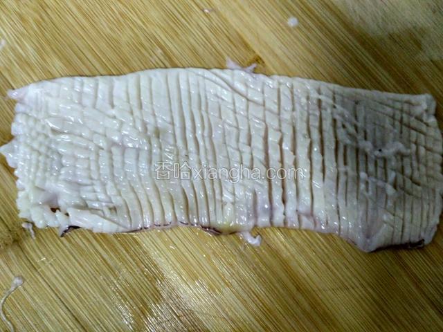 鱿鱼筒断尾，筒断开，去里面的骨刺，一分为二好切。
花刀切法：刀60度向内斜切鱼身，间隔半公分，不切透（断），从一端到另一端较一个边45度开始切，全部切完。翻转鱼片180度，刀垂直问隔半公分，平行一个边开始切，不切断，全部切完。