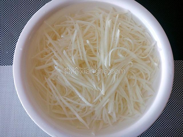 将土豆丝放入容器内，清水中加少许盐浸泡30分钟（泡在盐水中是为了防止土豆丝变色，炒制后更脆）。