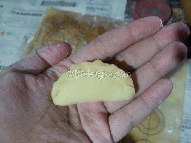 将面皮上放入花生碎，用手捏出花边