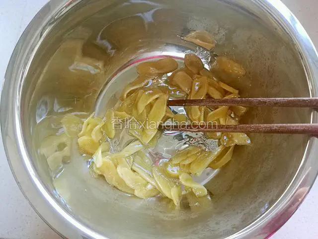 熬好后把姜和糖浆倒入不锈钢盆中或者不粘锅都可以，用筷子快速翻炒。(注意这不是在火上)。