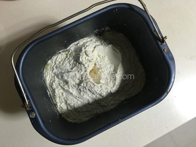 除黄油以外的主面团材料按先液体后粉类的顺序放入面包机桶中，启动和面程序20分钟；