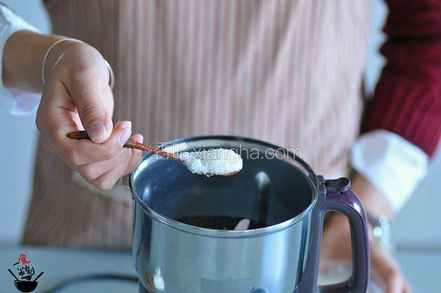 将炒好的黑芝麻放入粉碎机中，加入砂糖，粉碎～