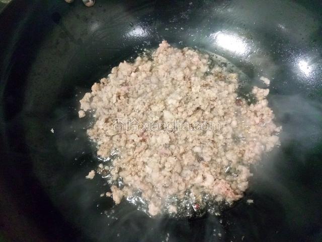 把肉末滑入锅中，微火，慢慢的炒香爆干油份。随着锅中油温慢慢的升高，此时加入一勺料酒去腥，再加半勺白糖提鲜。