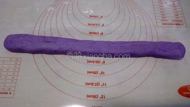 将紫薯面团放面板上，搓成一个长条。