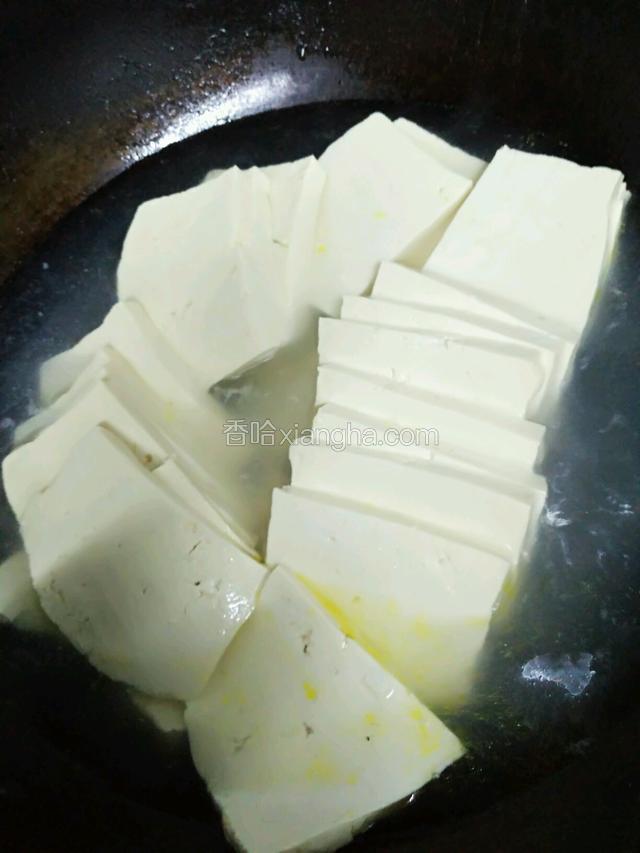 水煮豆腐，小心豆腐别碎掉。用铲子稍微推动豆腐都沾水就行。大火煮五分钟。（我的锅里有炸花生的余油）