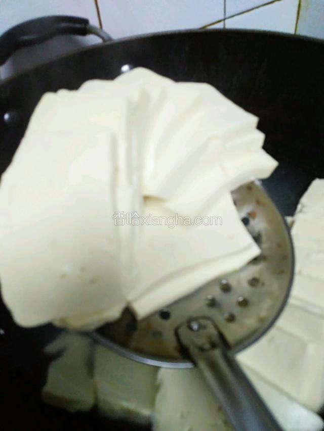 豆腐煮好后保持形状捞出摆进盘子。