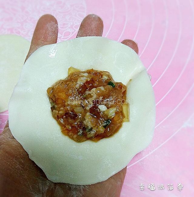 擀好的饺子皮放入肉馅。