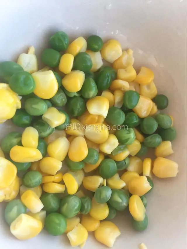 先把冷冻的青豆和玉米粒用开水焯一下，盛到碗里