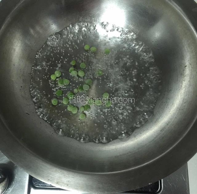 锅内烧开水下豌豆粒煮开。