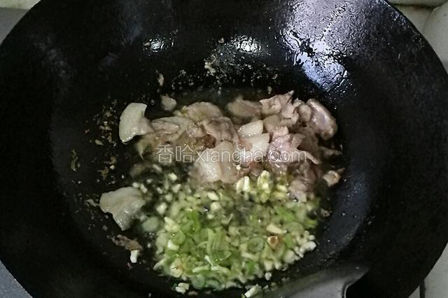 肉炒至出油，倒入葱蒜爆香。