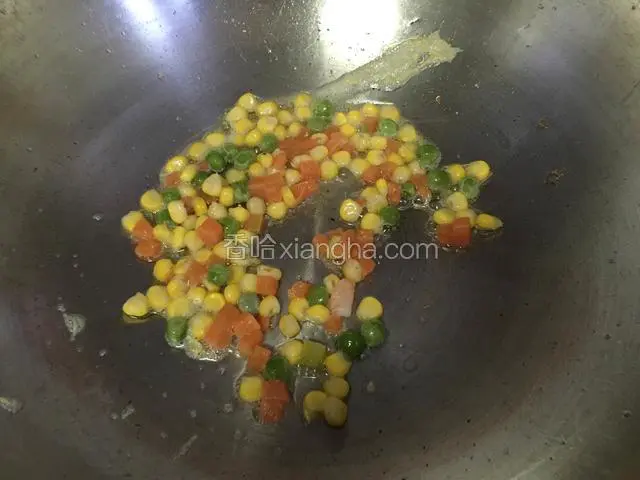锅内放油烧热，下豌豆粒玉米粒和胡萝卜丁焯熟盛出。