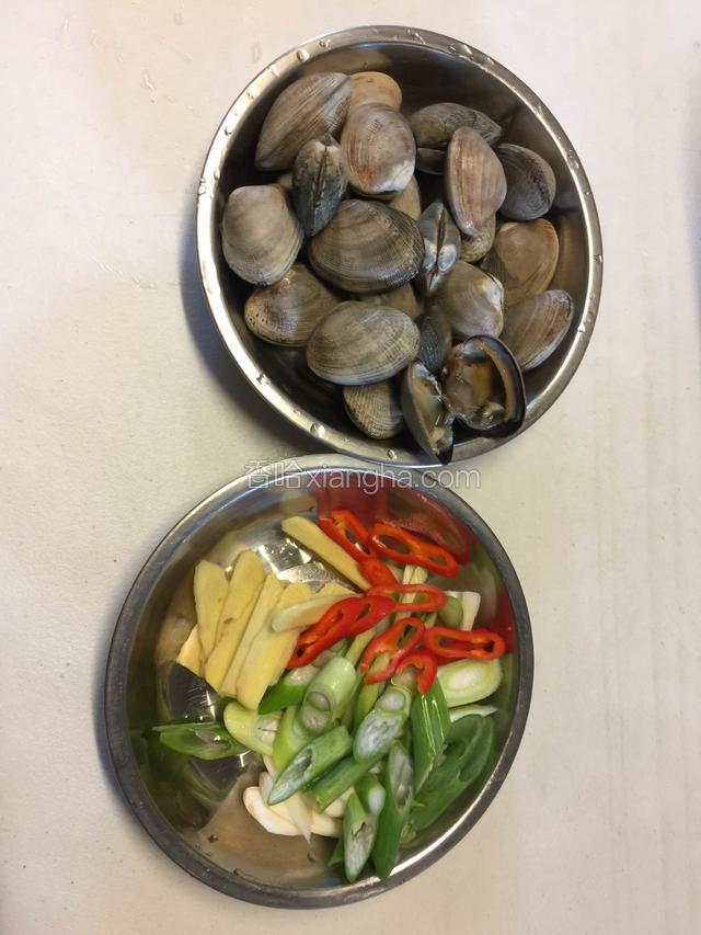 将花蛤洗净，姜切片，大葱切斜片，红椒切圆后待用。
