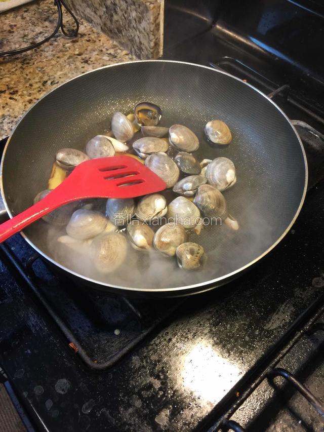 放入洗净的花蛤，半煎炒至贝壳打开，加入清酒，糖，鸡精，白胡椒粉，炒匀。