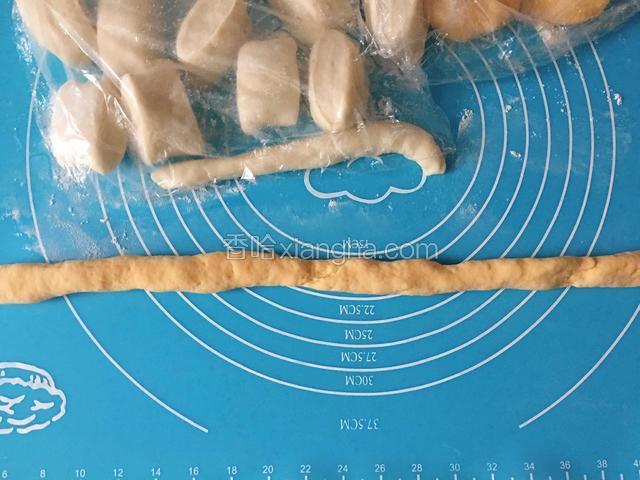 发酵好的南瓜面团取块面团搓成长条。