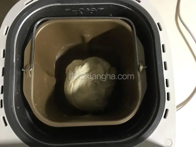 开启面包机揉面成序，将面团揉至光滑，盖上顶盖发酵十分钟；