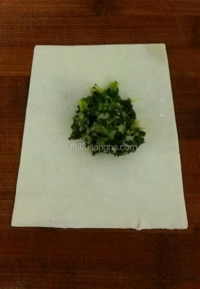 拿出一张馄炖皮，在皮子当中放一勺子馅
