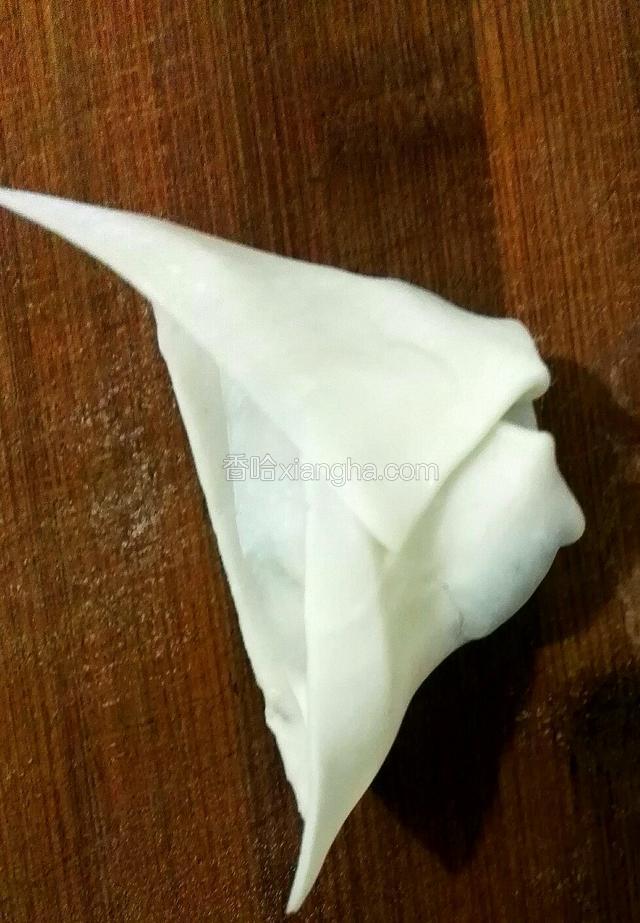 把捏紧的皮子的两个角交叉后再次捏紧