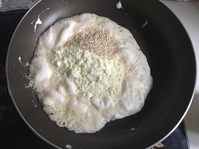 用搅拌刀翻拌均匀软化后加入奶粉和芝麻