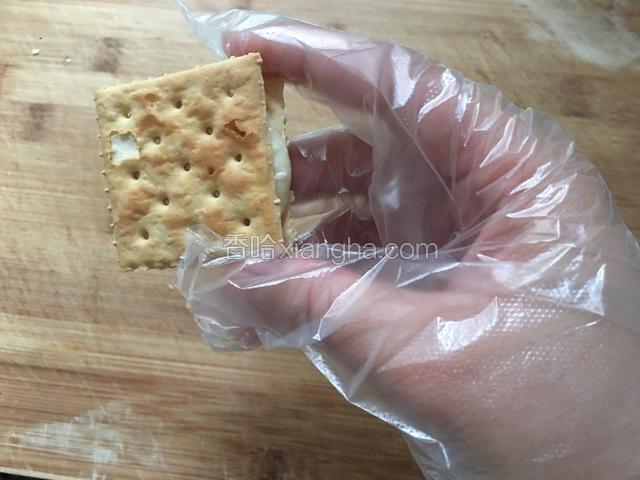 然后取一块梳打饼干盖在牛扎糖上面即可