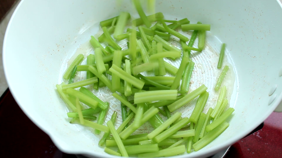 就着锅中底油倒入芹菜