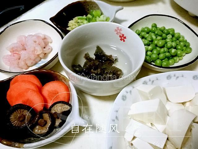 泡发好的海参切小段 用葱姜料酒加水煮五六分钟捞出备用 豌豆水煮断生捞出 虾仁放少许盐姜末生粉抓匀 胡萝卜香菇改刀切小 豆腐切小块
