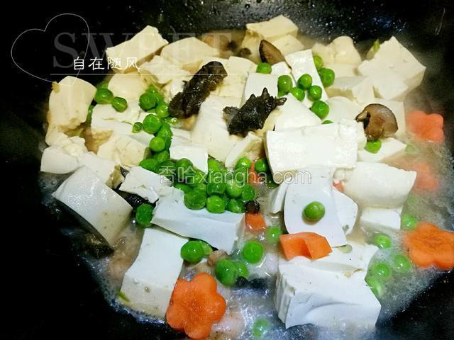 虾仁变色后加入海参段 少许高汤煮沸 加适量盐 将豆腐豌豆胡萝卜倒入锅中 
