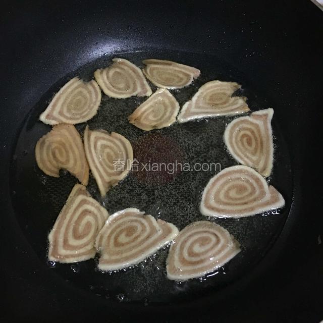 锅中倒入油，小火炸，炸至微黄变硬