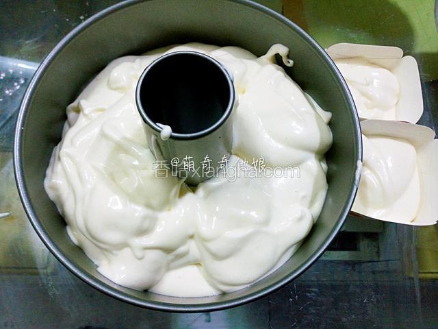 离模具10cm高处倒入模具中，震出大气泡，抹平。我格外分出了两杯做纸杯蛋糕（原因看的最后一步）。你们可以全部倒入。