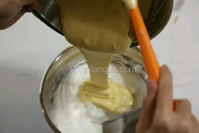 再把混合好的蛋糕糊与剩下的三分之二的蛋白用翻拌的手法轻轻混合