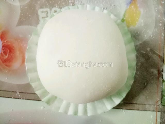 周边沾上水包起来，捏紧收口处后底部朝下放桌上，两手转转让雪媚娘更圆，最后放纸托里即可。