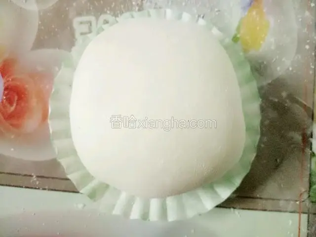 周边沾上水包起来，捏紧收口处后底部朝下放桌上，两手转转让雪媚娘更圆，最后放纸托里即可。