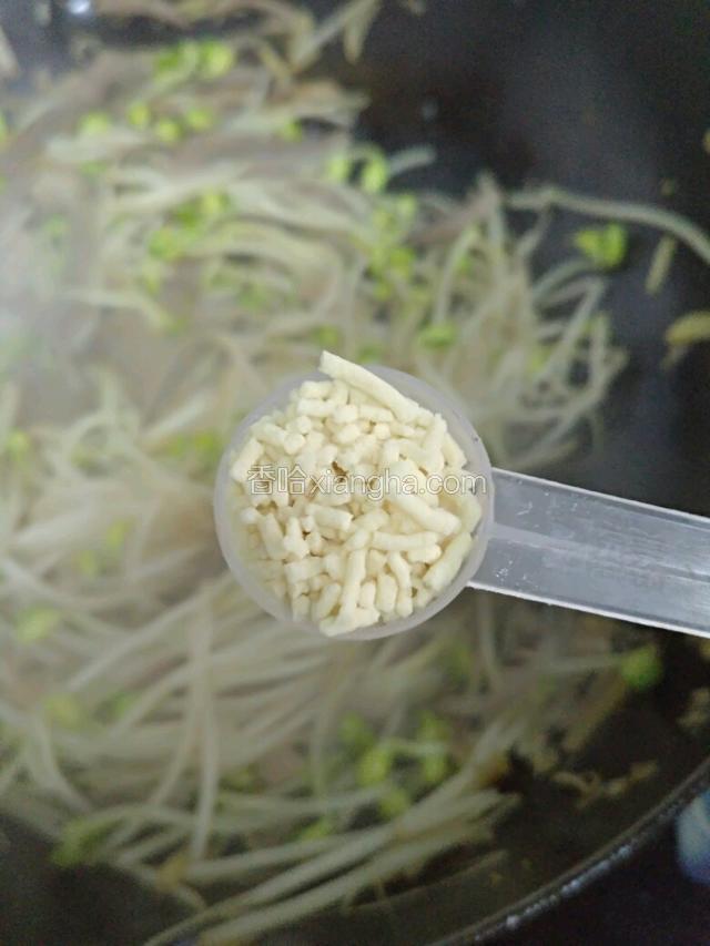 豆芽炒变色后，放鸡精，肉和豆芽一起炒匀出锅。