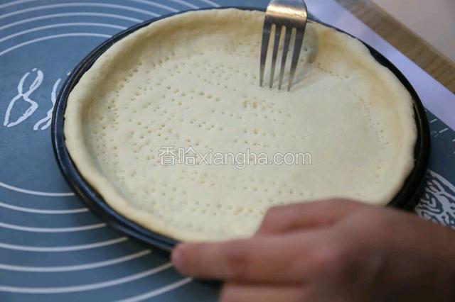 铺满整个披萨盘，用手掌尖把面团从中间往边上慢慢的推压。用餐叉在饼底戳孔后，放入冰箱冷藏半小时。