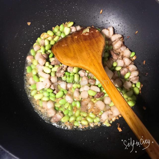 锅内倒少许油煸香姜蒜，倒入肉丁翻炒变色倒入毛豆接着翻炒片刻