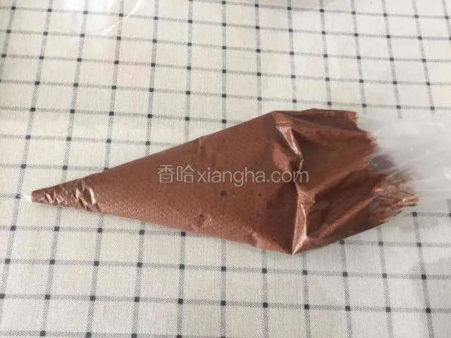 把翻拌均匀的可可糊装到裱花袋里。（150预热烤箱）