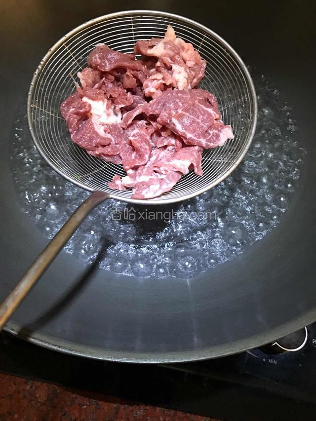 倒入适量水大火煮开后，把肉片放在捞勺上，放入沸水中烫焯至变色即可。