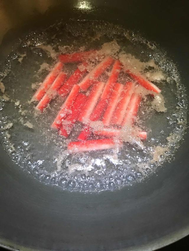 继续保持沸腾状态，放入蟹柳，煮熟后捞出分放碗中。