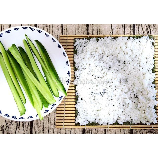 日本青瓜切长条，在紫菜上铺满醋饭（注意四角和边上都要铺均匀）